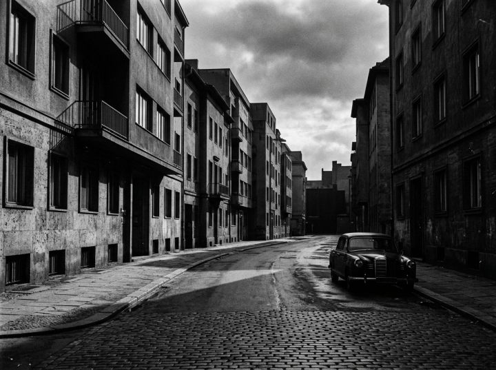 Vintage sedan parked on a quiet cobblestone city street